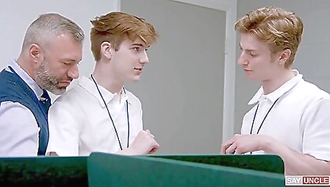 Two girls and a guy fuck two dicks in front of one guy