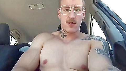 Tattooed babe in a black car is stroking her shaved pussy